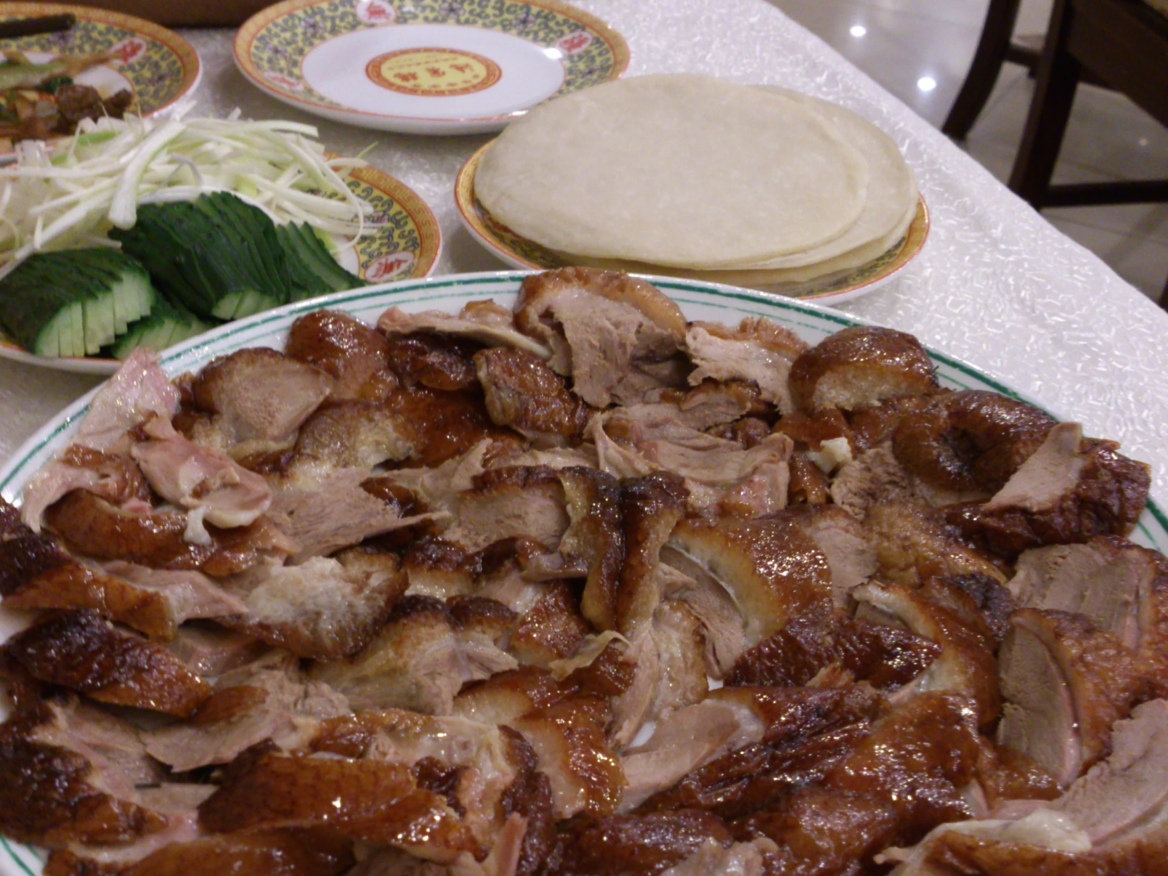 Sliced Beijing roast duck with pancakes, shredded scallions, and cucumber
