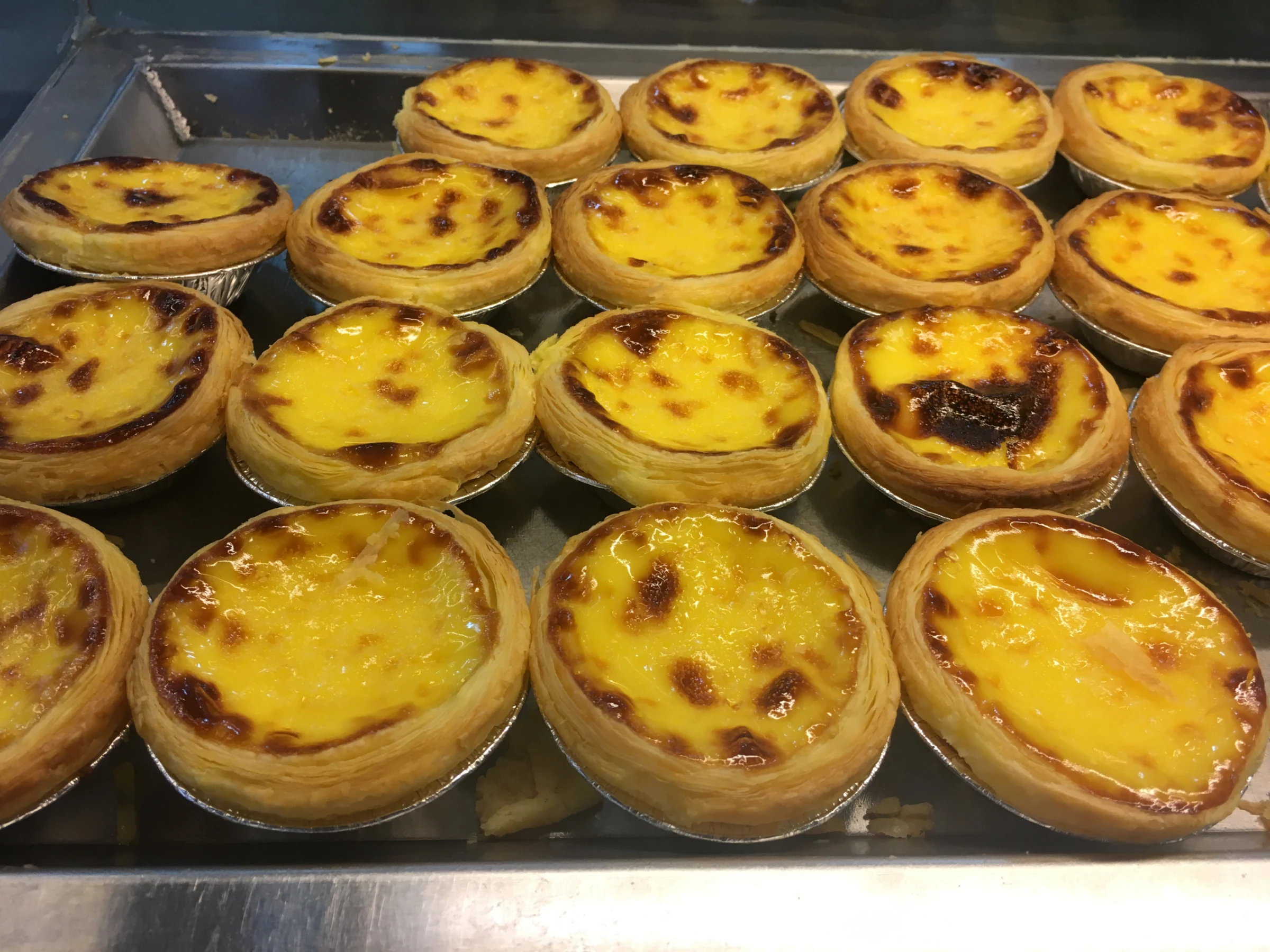 A plate of Portuguese egg tarts with browned tops in June 2019; the shop is not identified
