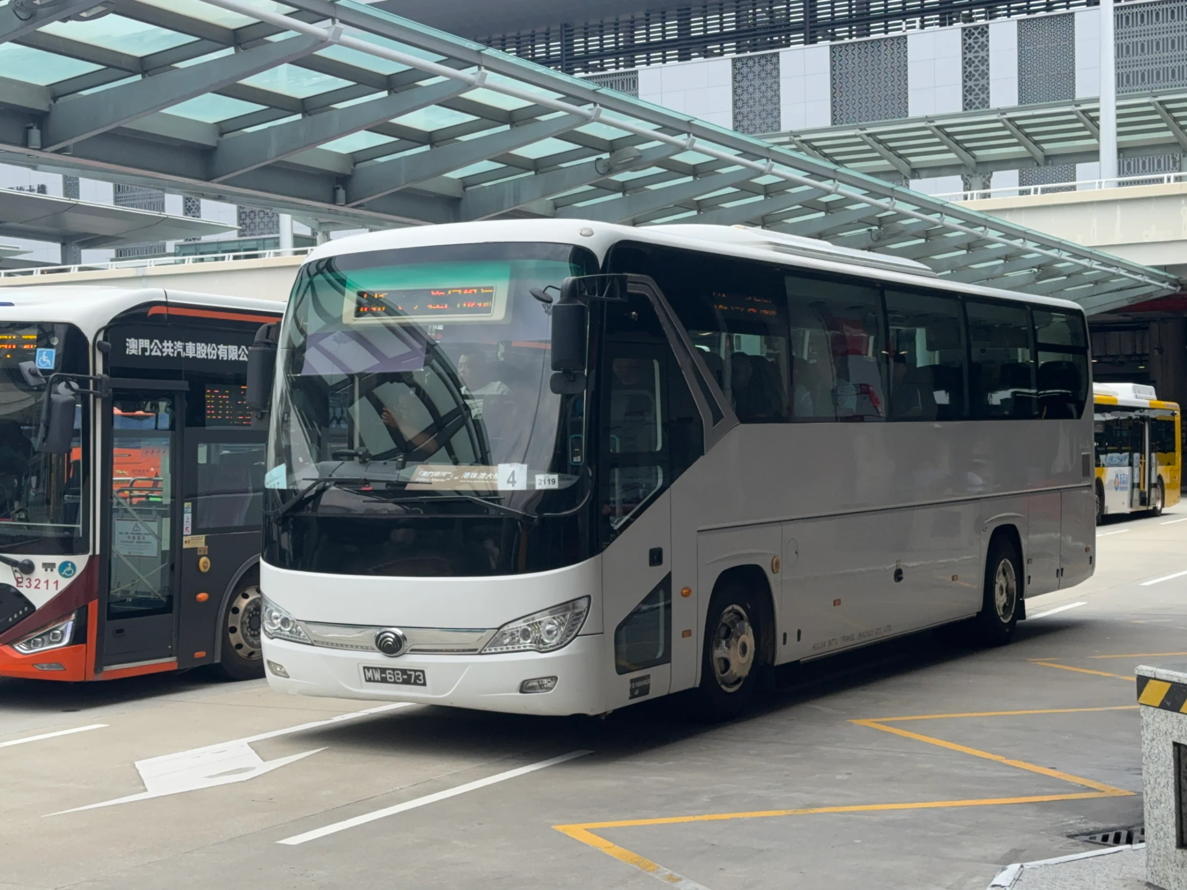 White shuttle to Galaxy parked at the Hong Kong–Zhuhai–Macau Bridge Macau Port in June 2026