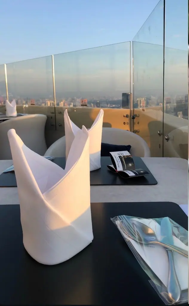 Baiyoke Sky 的 Bangkok Balcony，夕陽照在白餐巾上