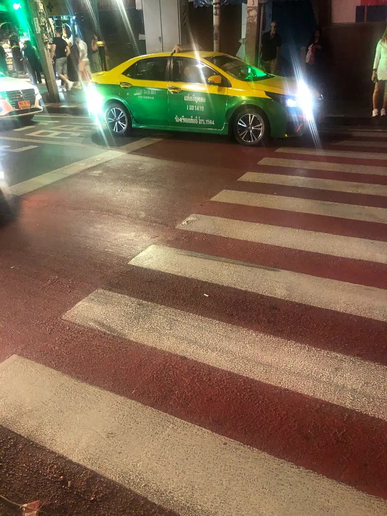 夜間斑馬線旁的綠黃計程車