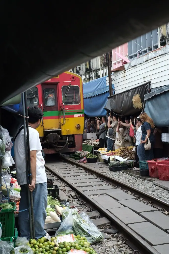 美功鐵道市場，火車從攤位中間進站