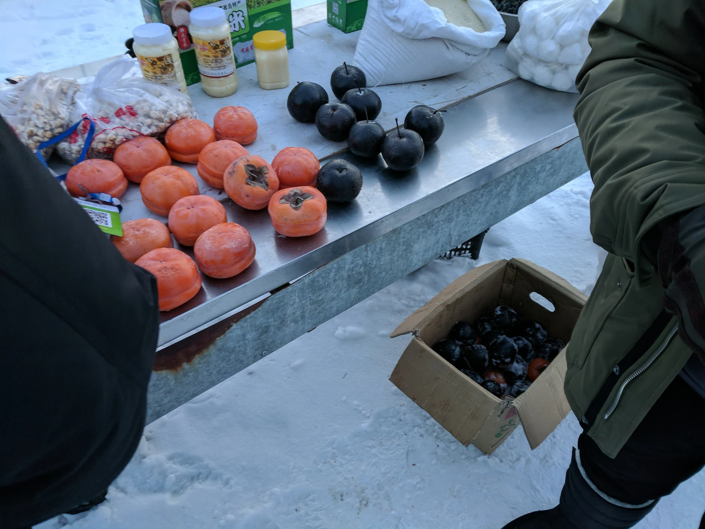 雪地攤位上的凍柿子與凍梨