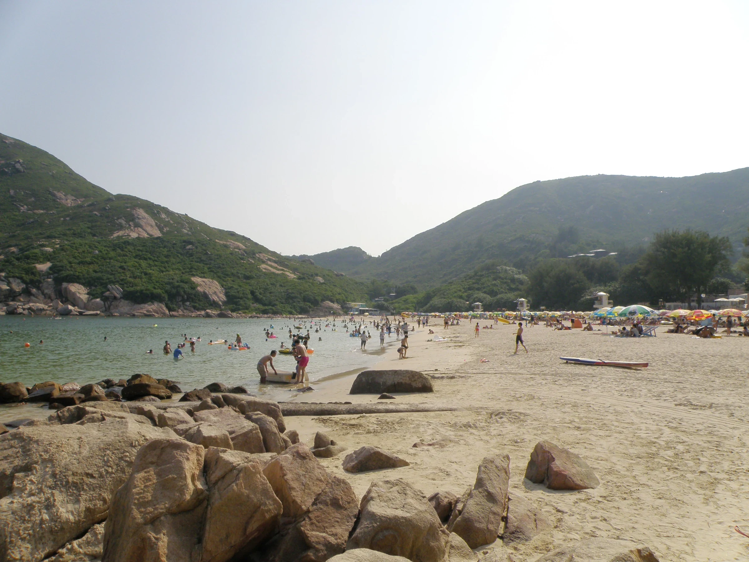 People swimming and using sunshades at Shek O Beach in August 2015