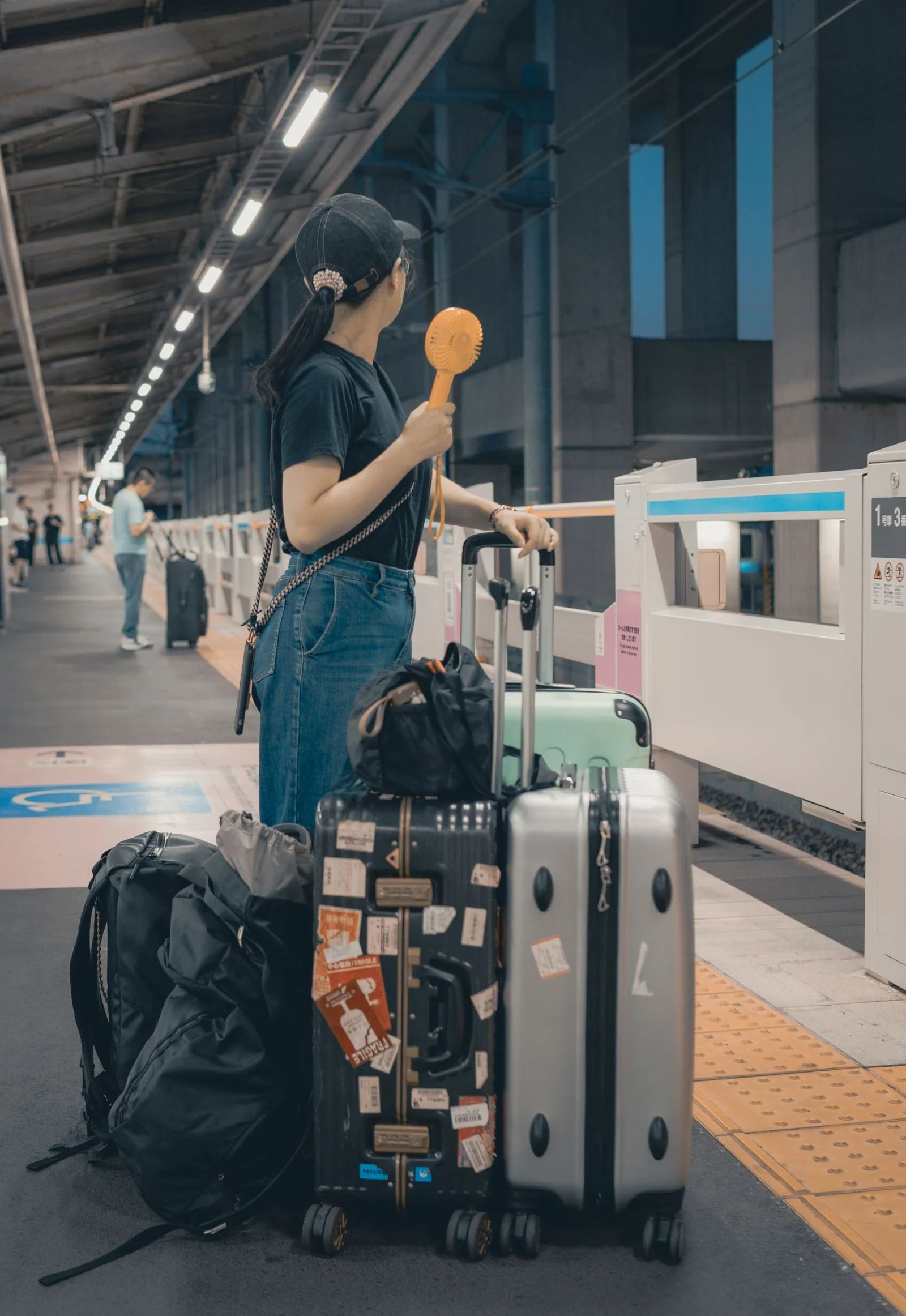 日本車站月台上帶著行李的旅客