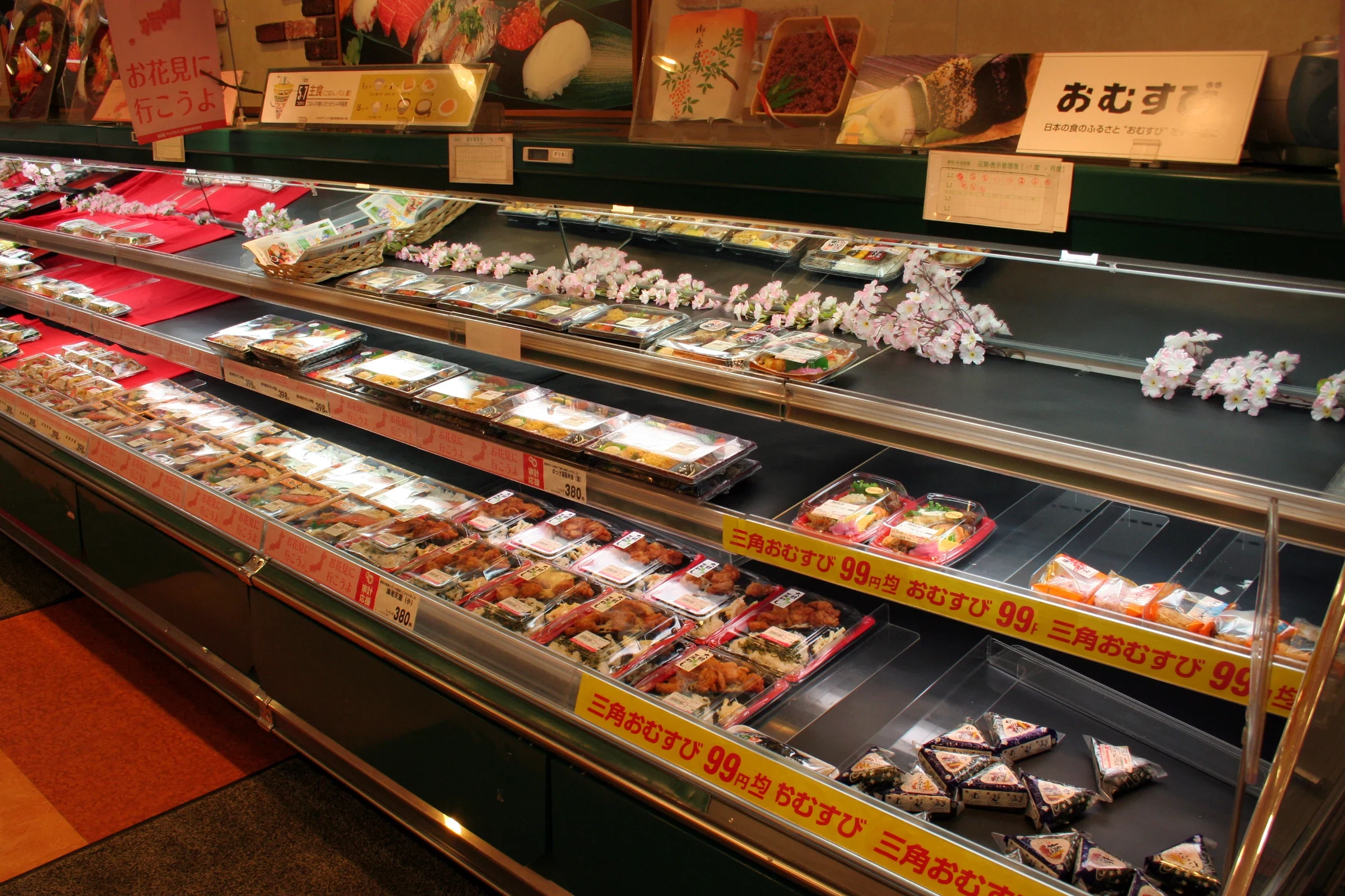 日本超市熟食架上陳列多款便當與飯糰