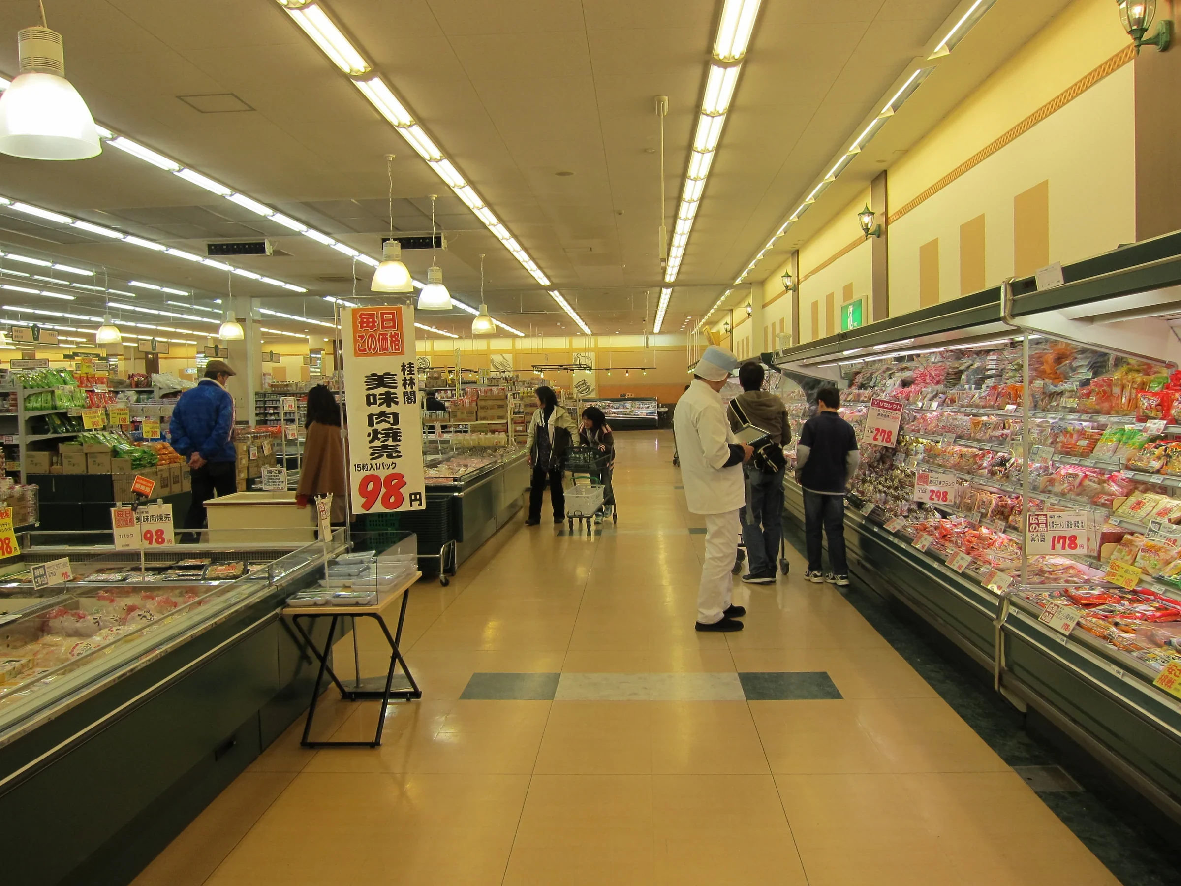 日本超市內的食品貨架與選購商品的顧客