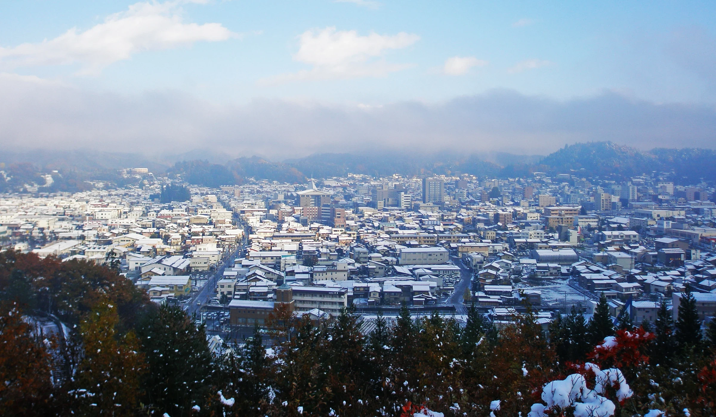 日本飛驒高山初冬城市俯瞰，街道與建築屋頂覆蓋薄雪