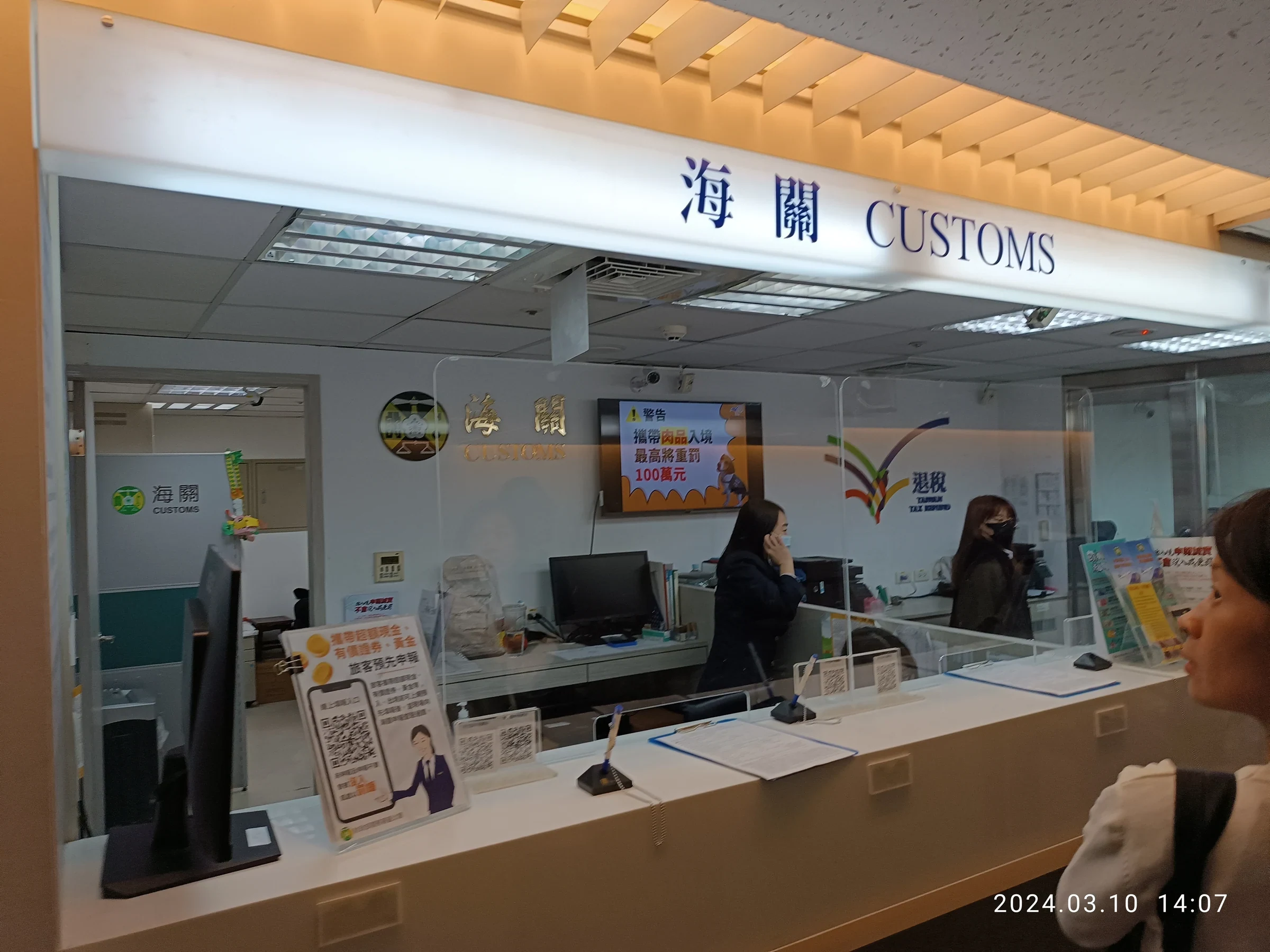 桃園機場第一航廈海關服務台，螢幕顯示攜帶肉品入境最高重罰100萬元警告